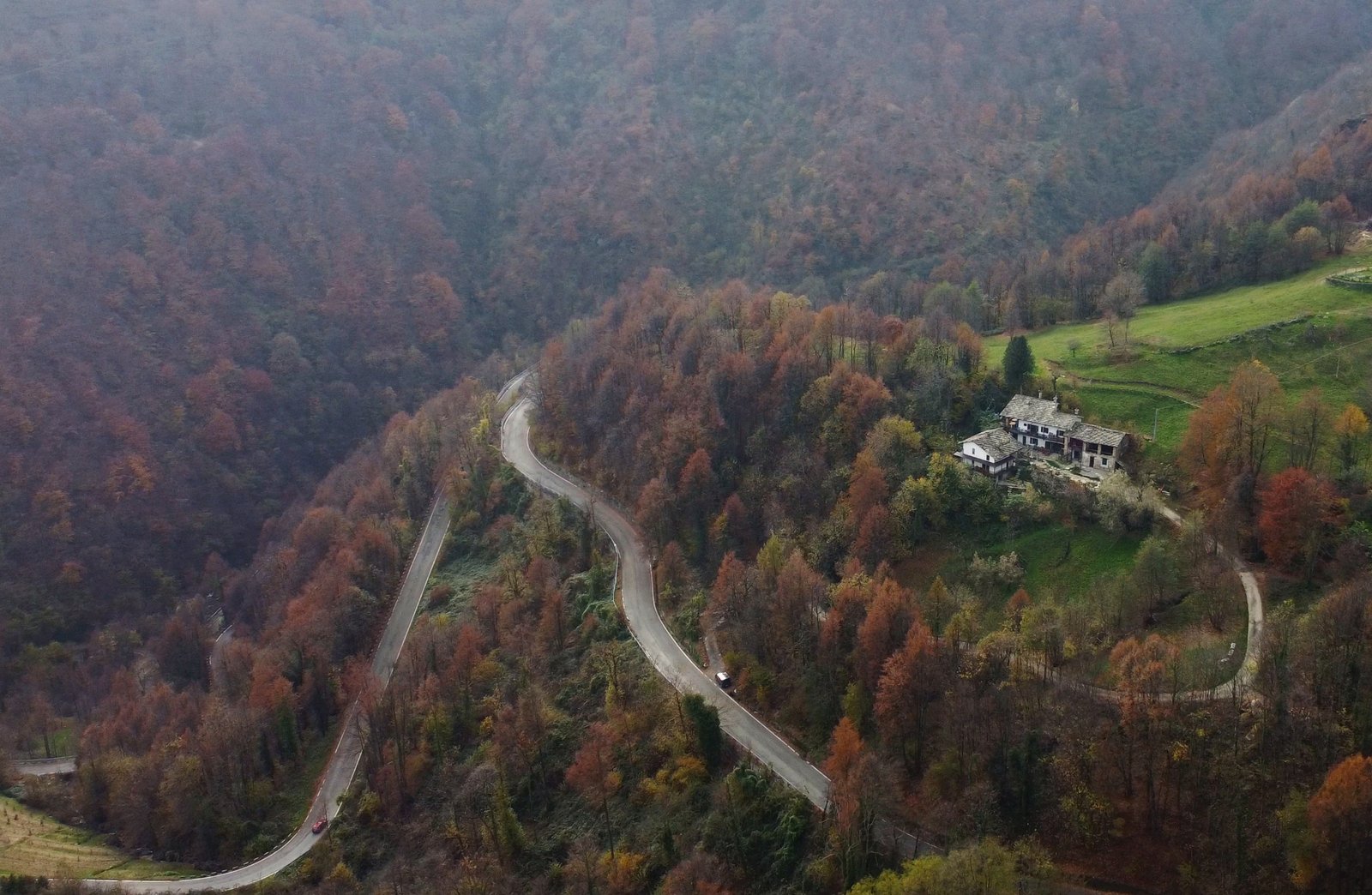 Stone Oven House beside a winding road among autumn woodland