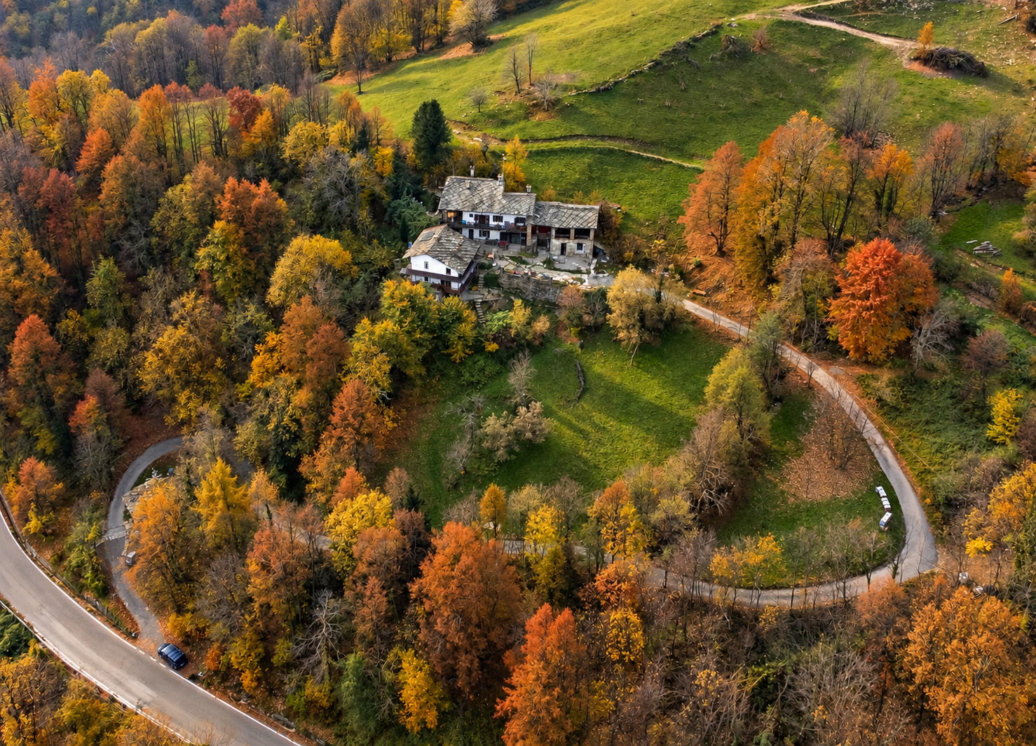 Stone Oven House and surrounding gardens, terraces and autumn woodland seen from above